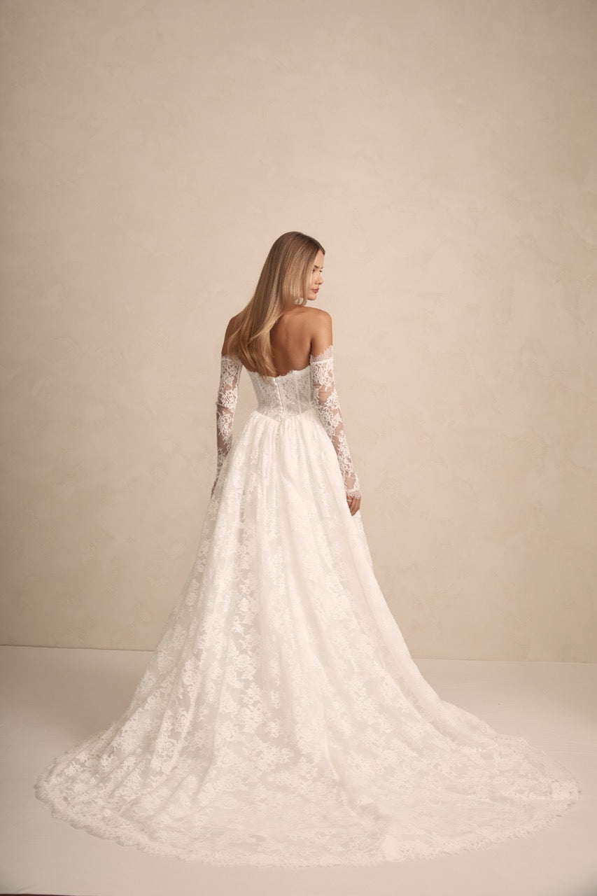 Prim Brautkleid in Bewegung – moderne Silhouette mit zarter Drapierung und sanftem Glanz.