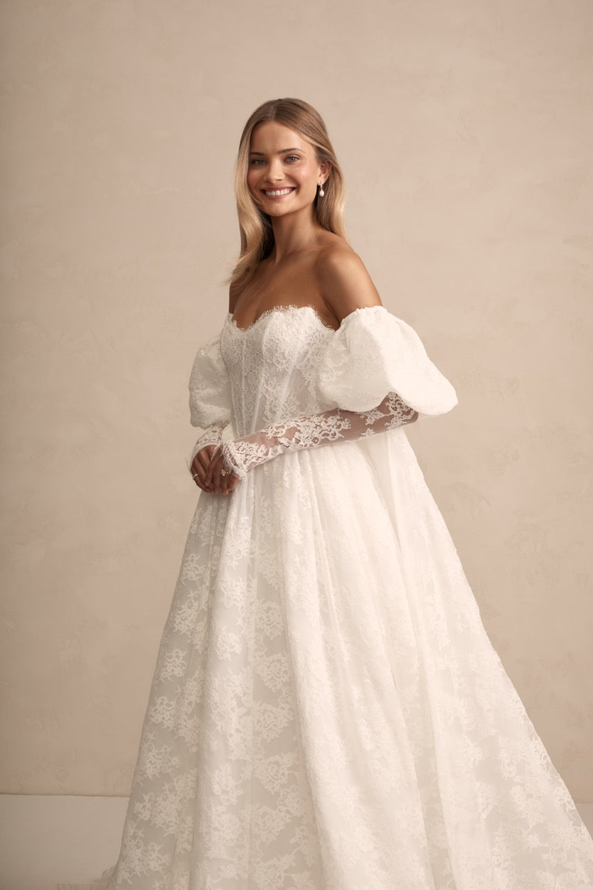 Romantische Braut trägt Prim von Made With Love mit passendem Cape – stilvoll und anmutig.