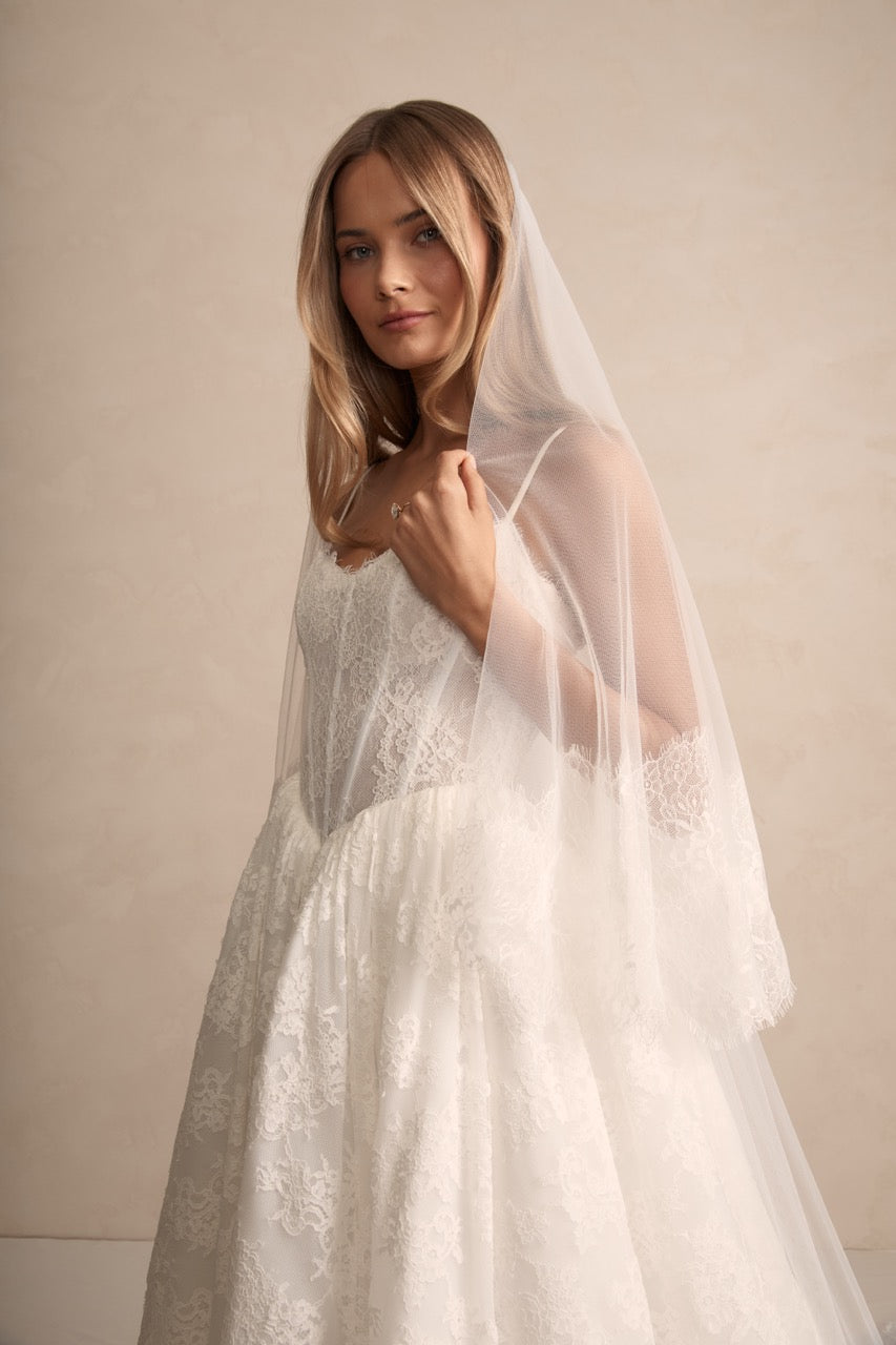 Braut mit dem Alice Blusher Schleier, verziert mit feiner Chantilly-Fransenspitze für einen modernen und eleganten Look.