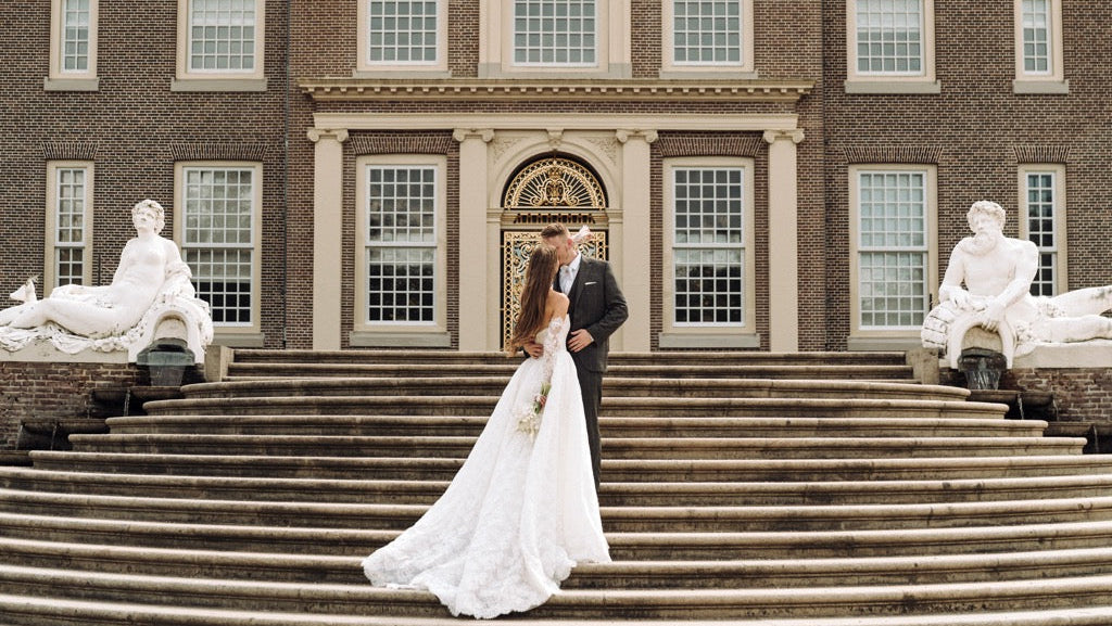 Braut und Bräutigam mit dem Schloss in Hintergrund.