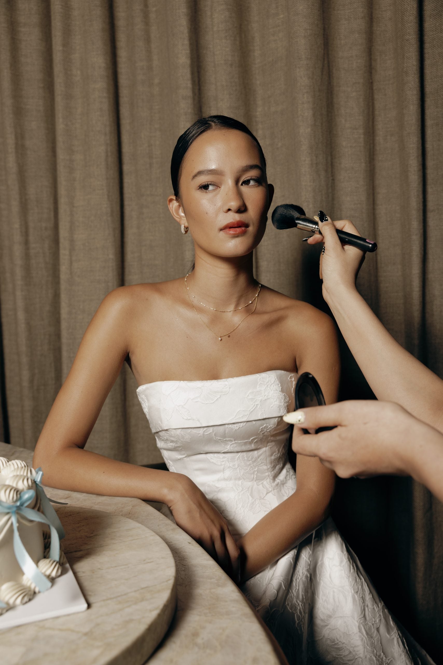 Detailaufnahme des Perth Brautkleids – skulpturales Mieder, Brokatrock und feine Perlenknöpfe entlang der Schleppe.