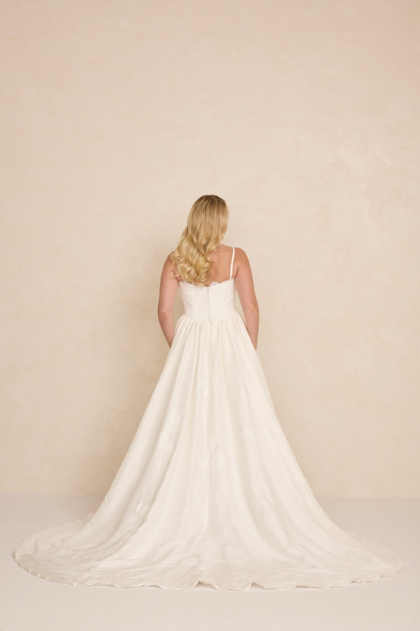 Rückenansicht des Brautkleids Adeline A-Linie von MWL Bride mit klarer Silhouette und natürlichem Stofffall.