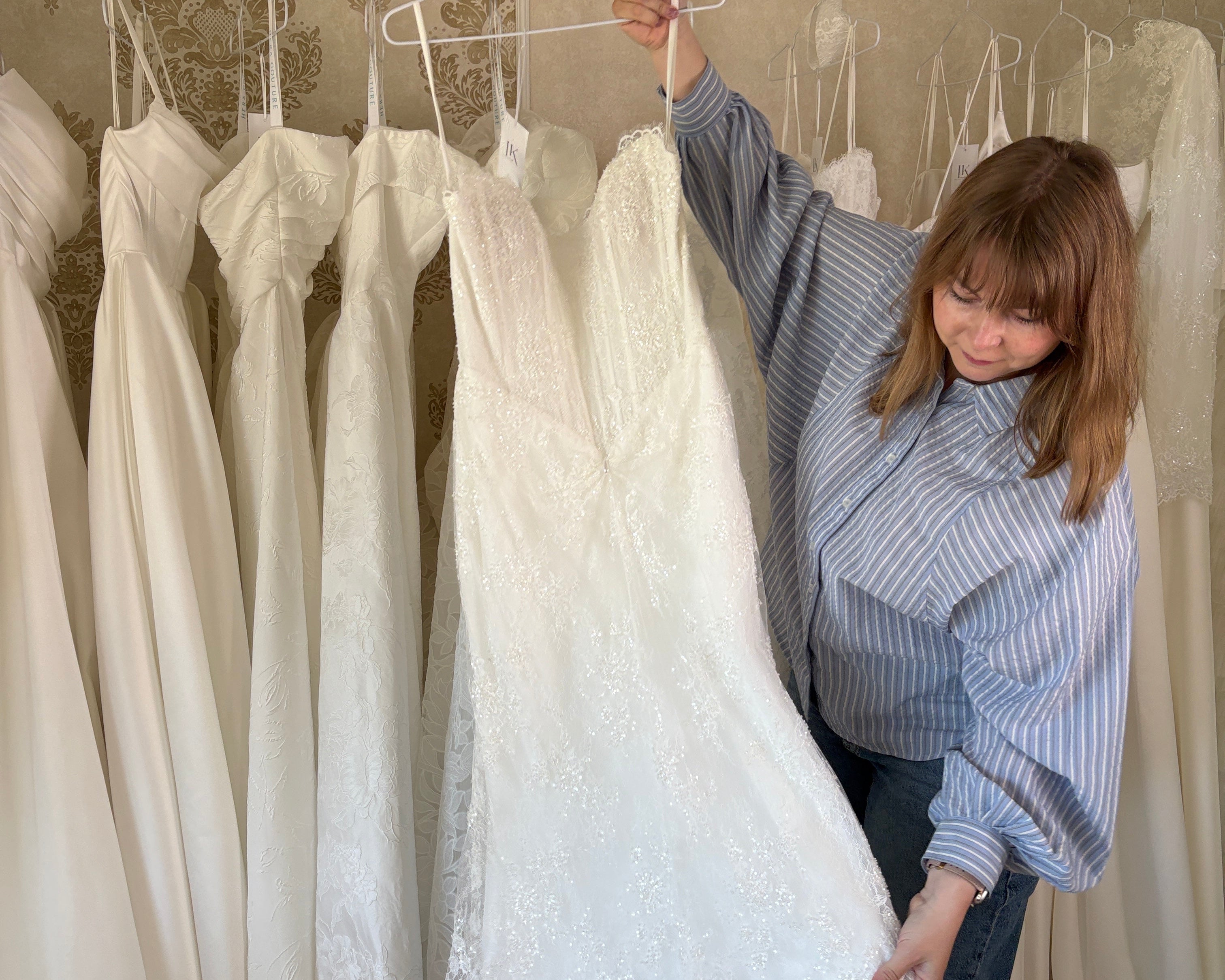 Brautstylistin von Lys Kyss Bridal zeigt Brautkleid der Braut
