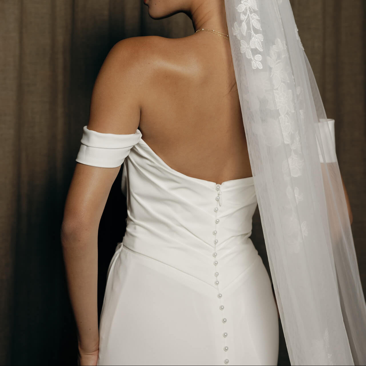 Cleanes Brautkleid von Hera Couture in Wuerzburg verziert mit den kleinen Perlenknöpfen
