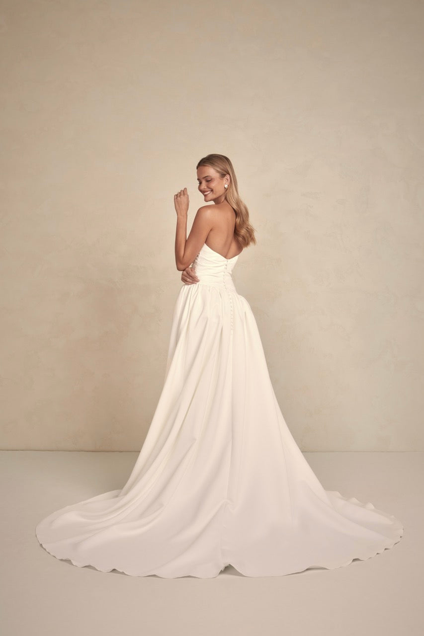 Braut in Avery von Made With Love – elegantes, trägerloses Brautkleid aus mattem Duchess-Satin mit skulpturaler Silhouette.