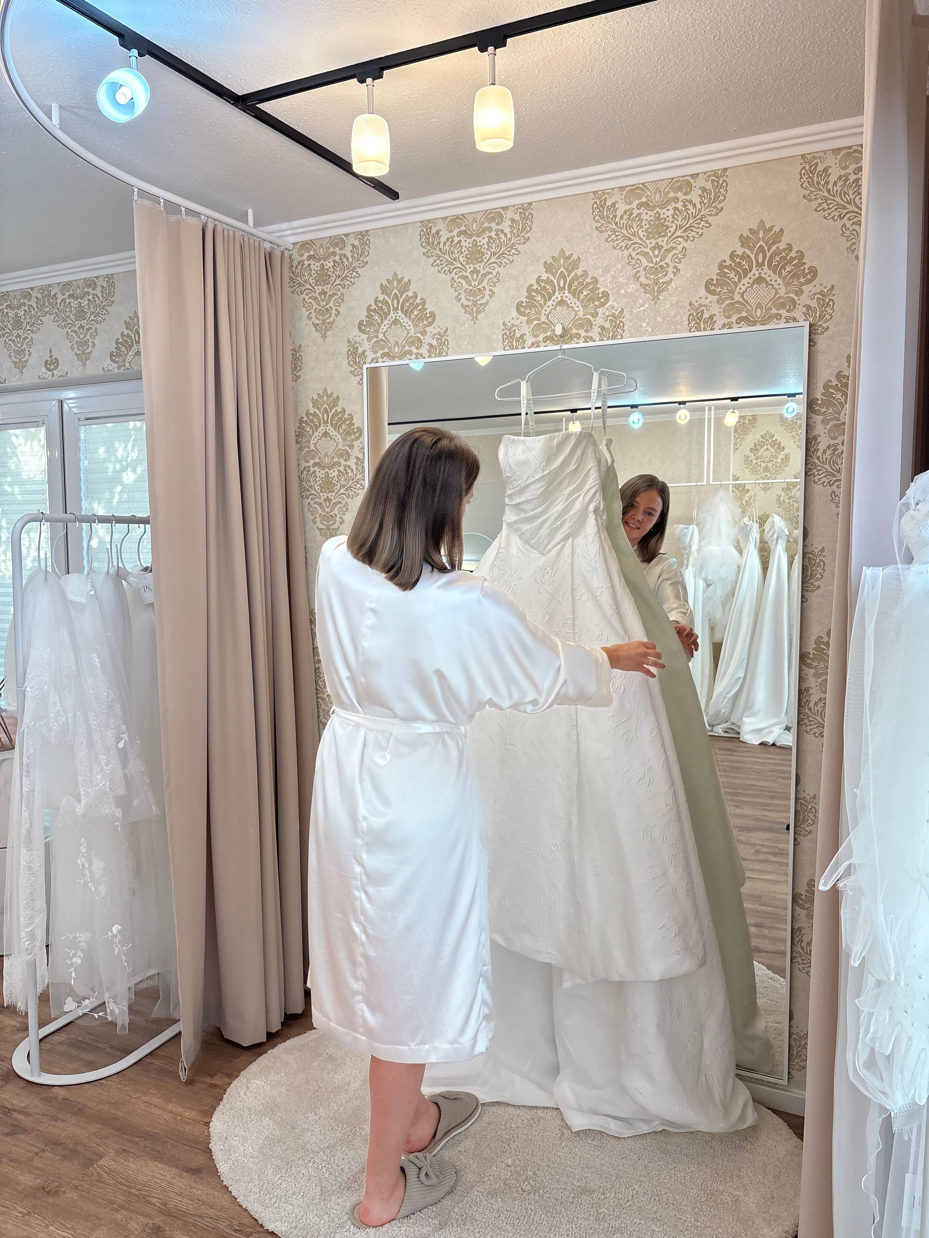 Braut probiert Brautkleid im Brautmodengeschäft in der Nähe von Würzburg