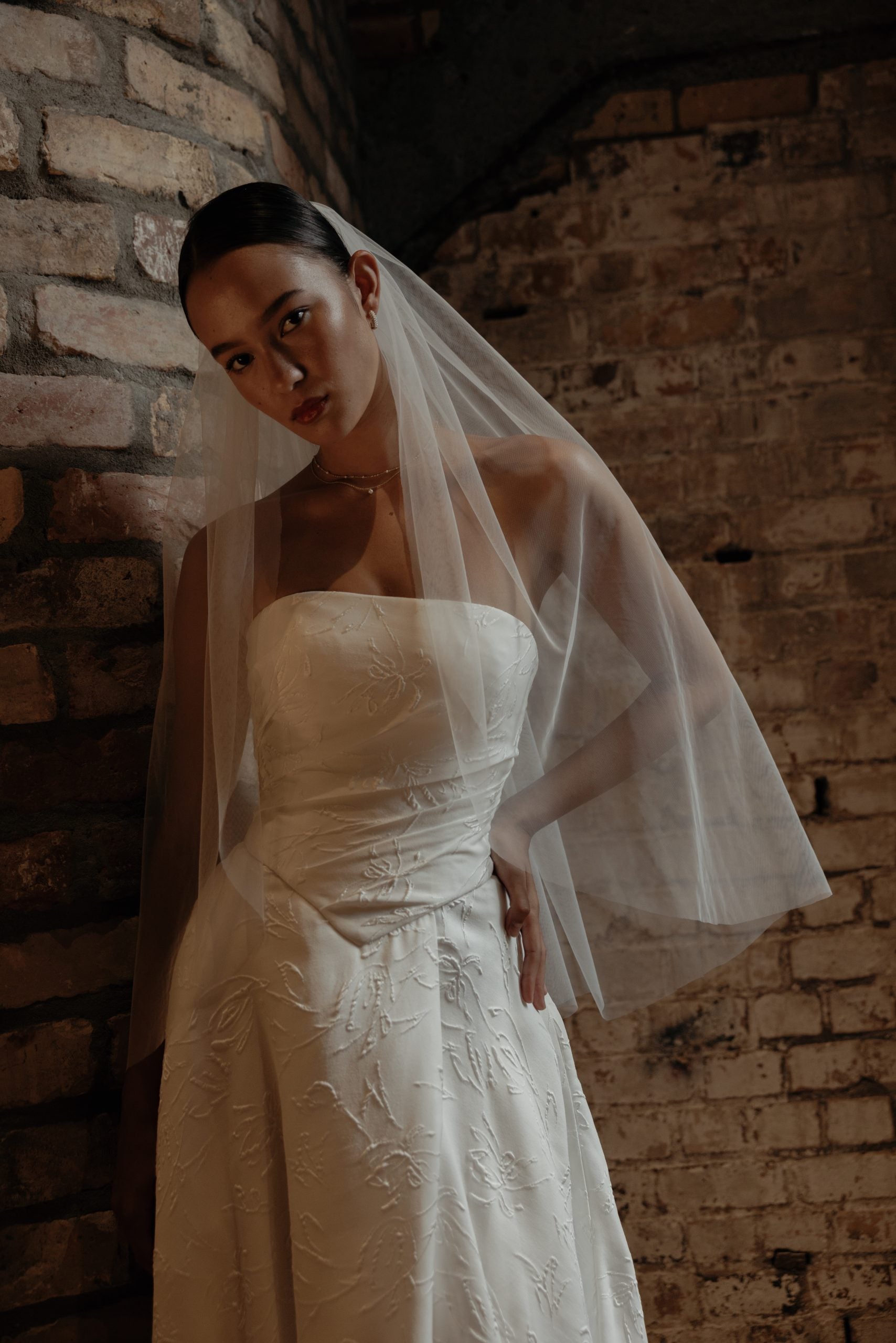 Detailaufnahme des Ponsonby Brautkleids – strukturiertes Jacquard, definierte Basque-Taille und puristisches, trägerloses Mieder.